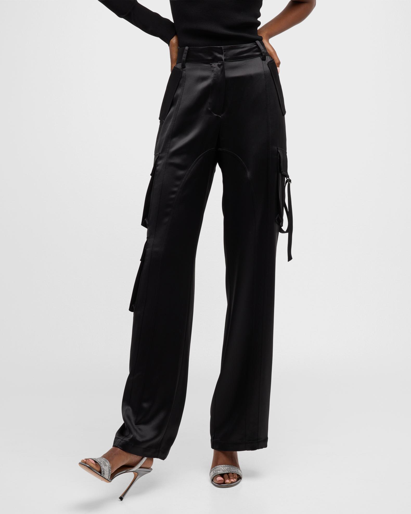 Black satin cargo pants with fluid wide legs, draped thigh pockets and light reflecting along the folds