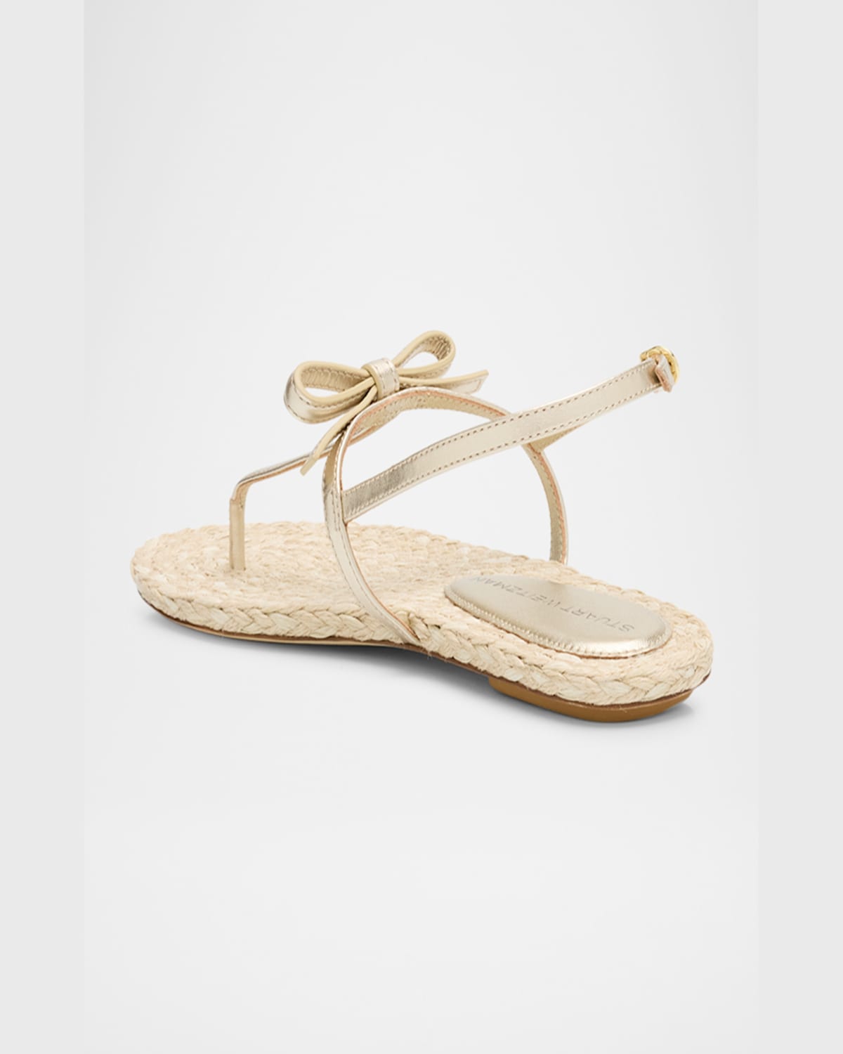 Shop Stuart Weitzman Felicity Metallic Bow T-strap Sandals In Light Goldnatural