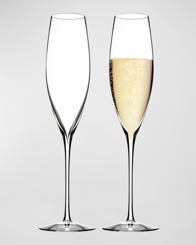 One empty champagne flute and one champagne flute with champagne in it